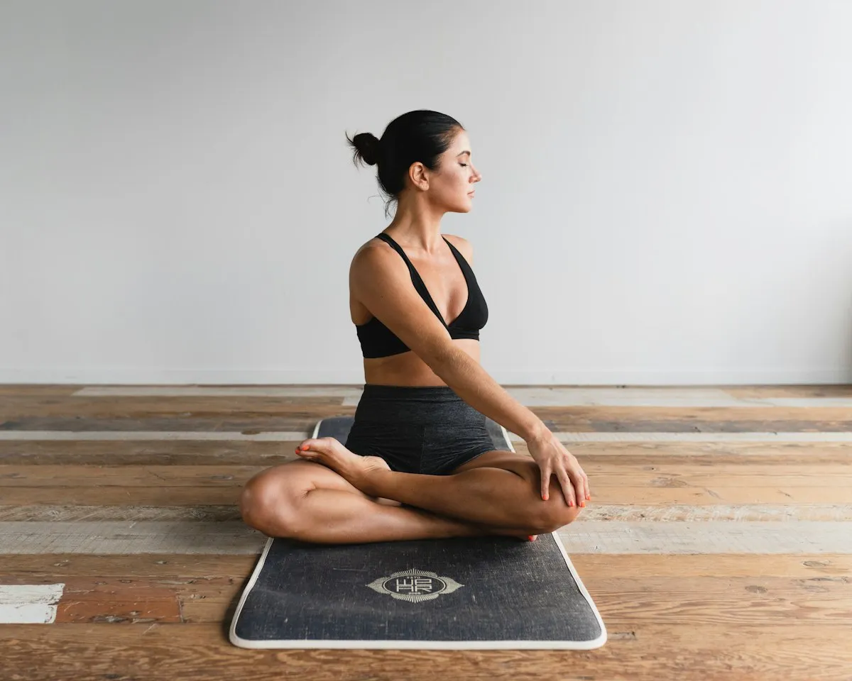 Woman doing a seated twisting stretch for her back on a mat